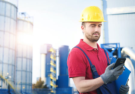 Frontline Factory Worker wearing a red shirt and using a tablet.